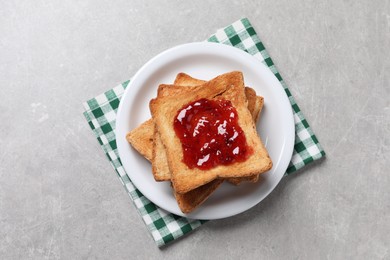 Photo of Delicious toasts with jam on light table, top view