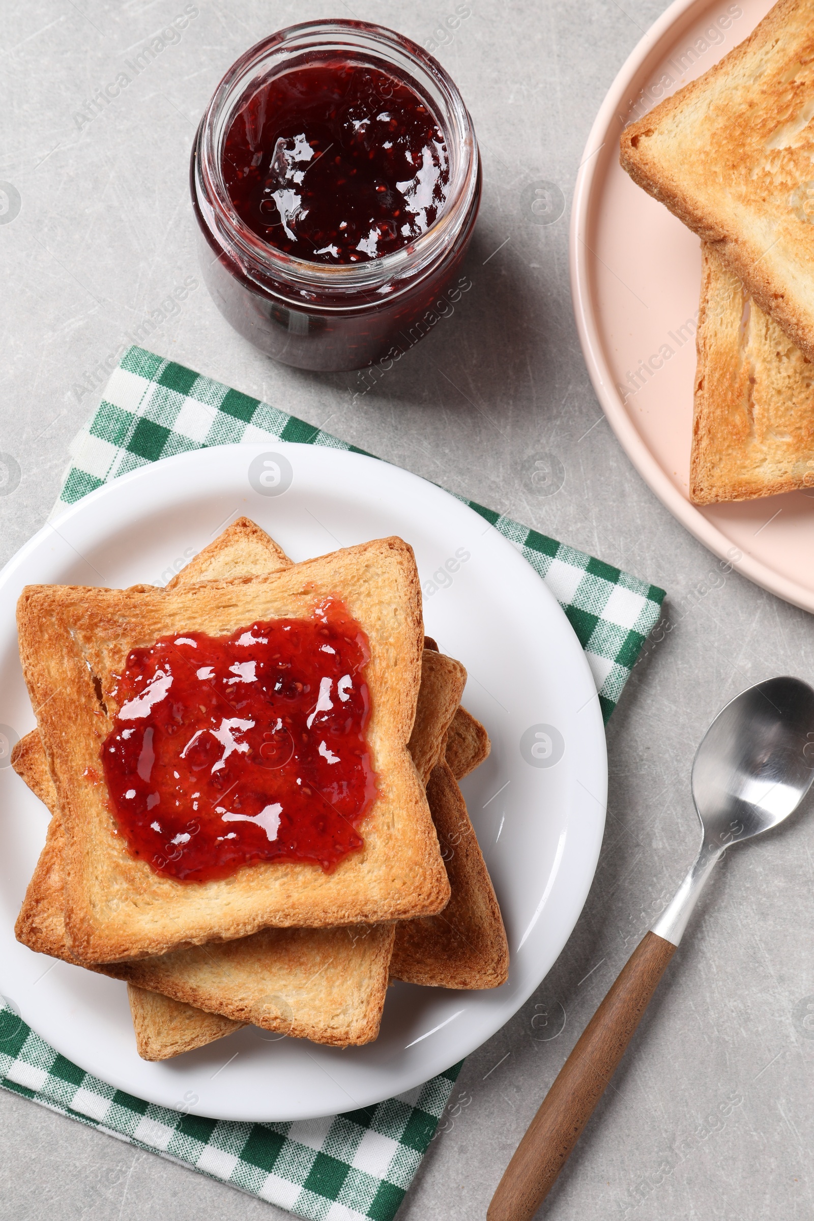 Photo of Delicious toasts with jam on light table, flat lay