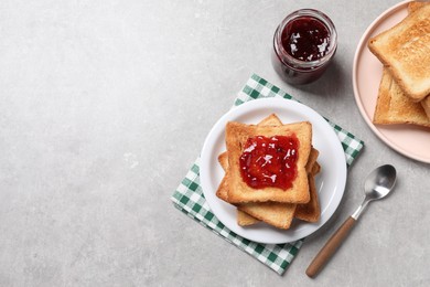 Delicious toasts with jam on light table, flat lay. Space for text