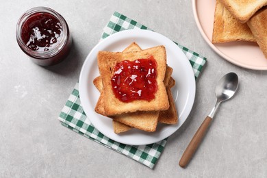 Photo of Delicious toasts with jam on light table, flat lay