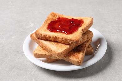 Photo of Delicious toasts with jam on light table, closeup