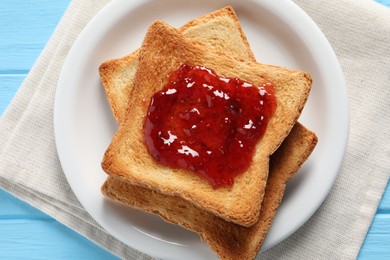 Photo of Delicious toasts with jam on light blue wooden table, top view