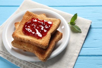 Delicious toasts with jam on light blue wooden table, closeup