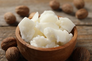 Natural shea butter and nuts on wooden table, closeup