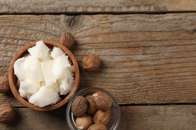 Photo of Natural shea butter and nuts on wooden table, flat lay. Space for text