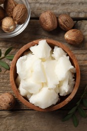 Photo of Natural shea butter and nuts on wooden table, flat lay