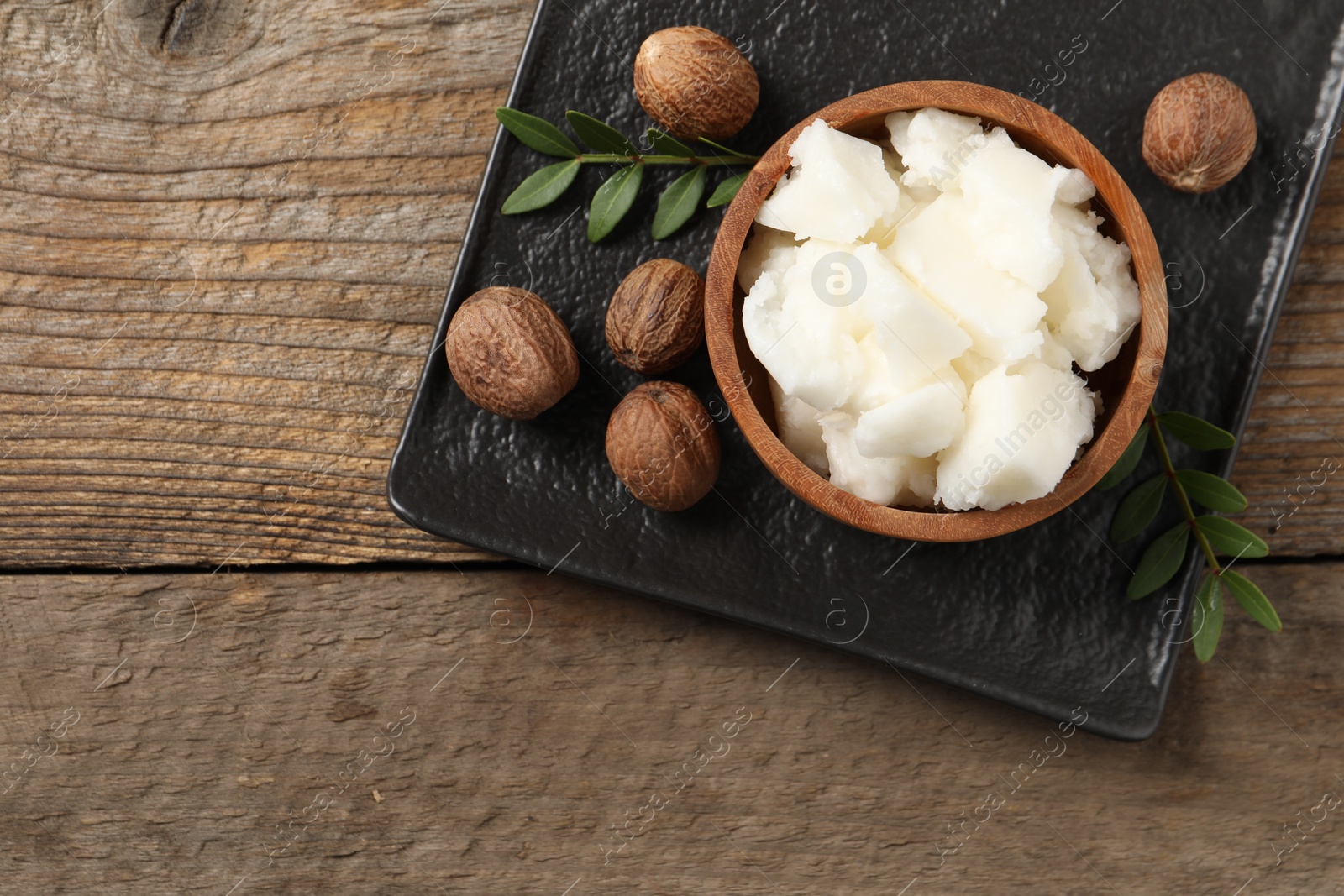 Photo of Natural shea butter and nuts on wooden table, top view