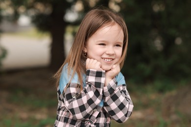 Portrait of happy little girl outdoors. Cute child