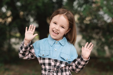 Photo of Portrait of happy little girl outdoors. Cute child