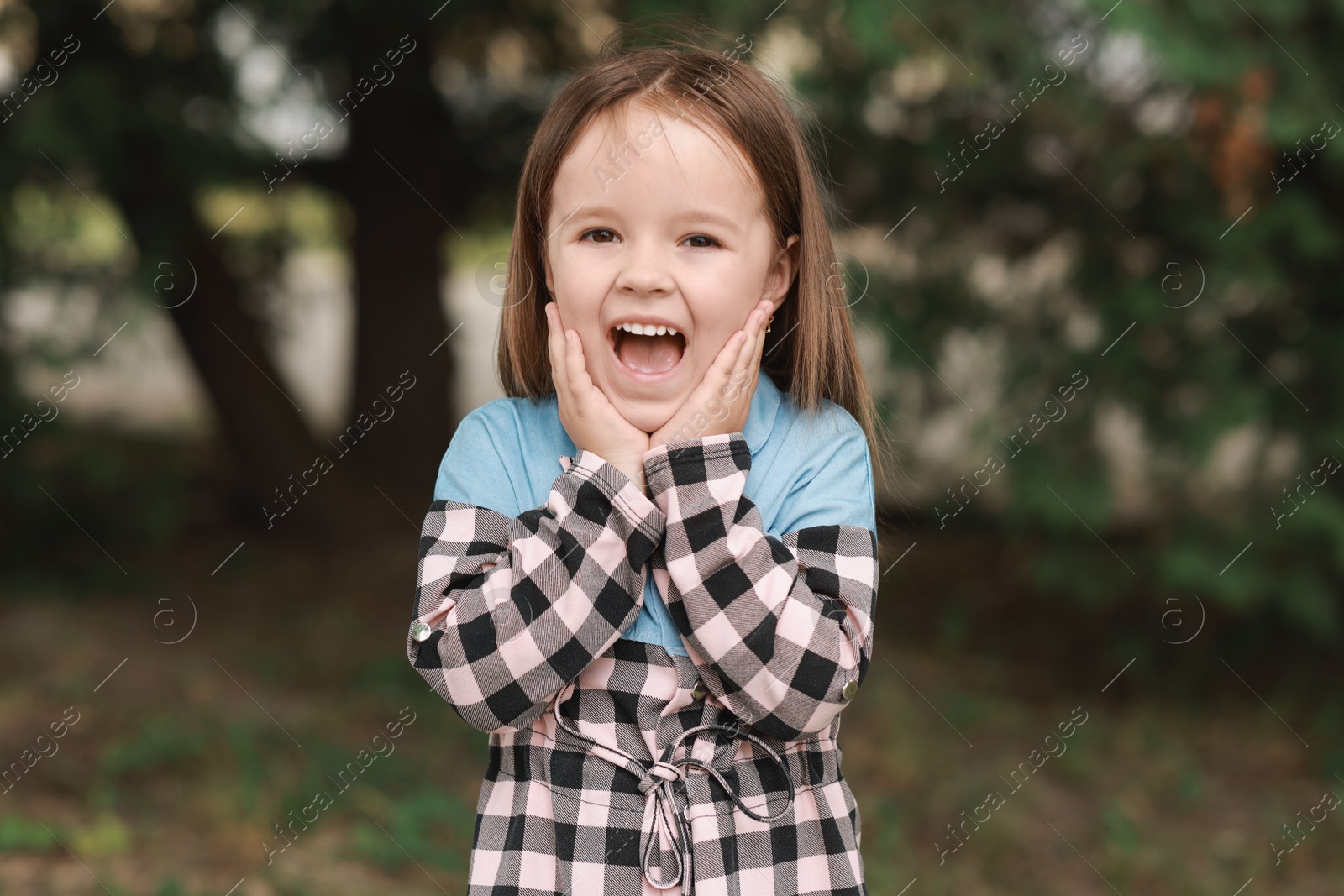 Photo of Portrait of emotional little girl outdoors. Cute child