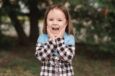 Portrait of emotional little girl outdoors. Cute child