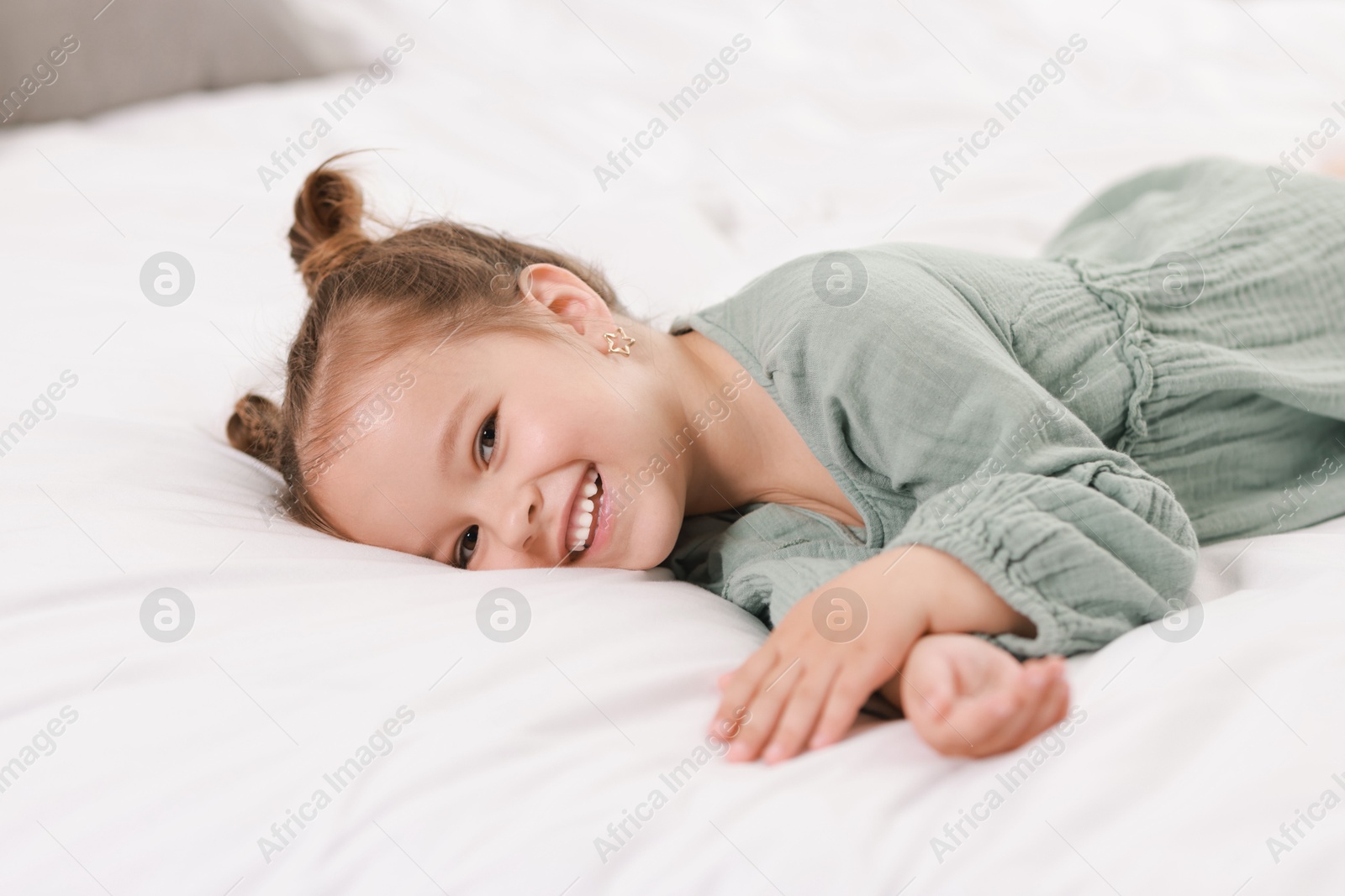 Photo of Portrait of happy little girl on bed