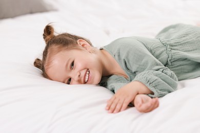 Photo of Portrait of happy little girl on bed