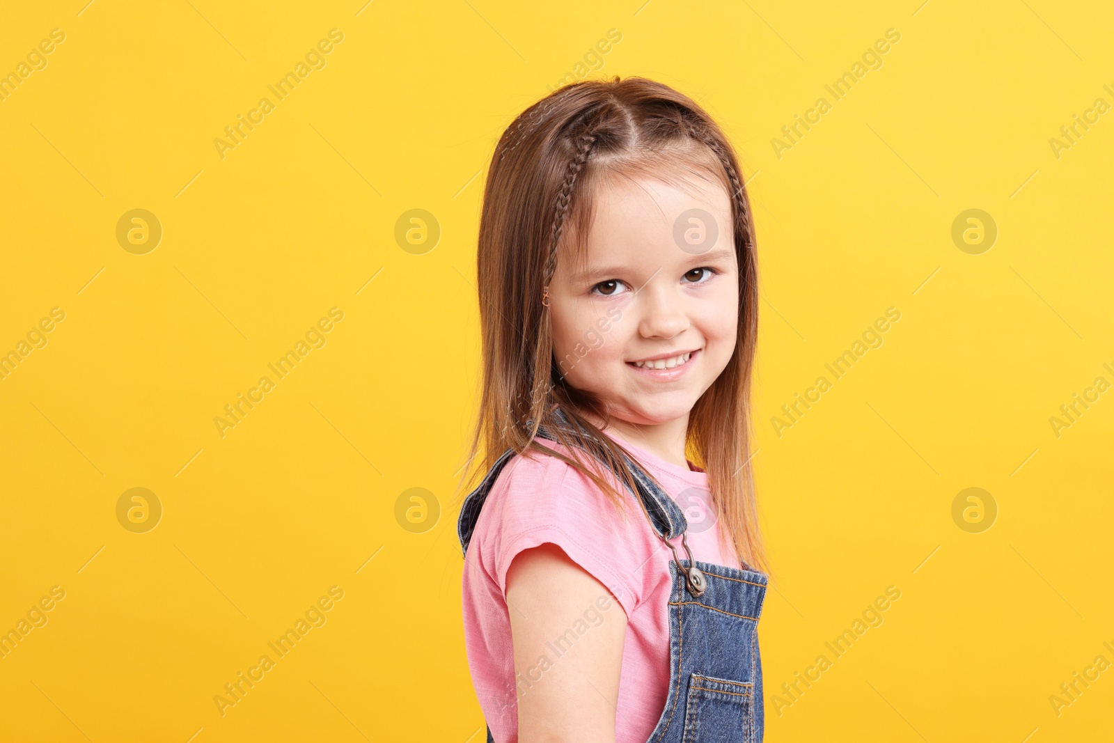 Photo of Portrait of happy little girl on orange background