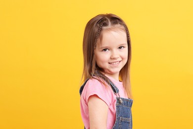 Photo of Portrait of happy little girl on orange background