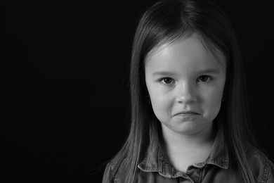 Photo of Portrait of sad girl on dark background, space for text. Black and white effect