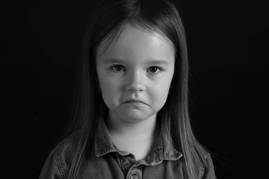 Portrait of sad girl on dark background, closeup. Black and white effect