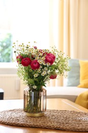 Photo of Beautiful ranunculus flowers and chamomiles in vase on table indoors