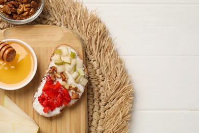 Delicious ricotta bruschetta with pear, strawberry and on white wooden table, top view. Space for text