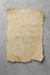 Photo of Sheet of old parchment paper on grey table, top view