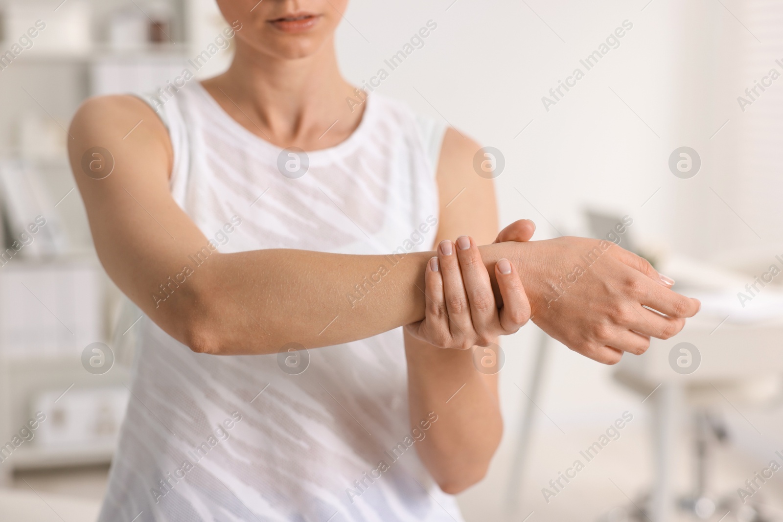 Photo of Sports injury. Woman with pain in wrist in hospital, closeup