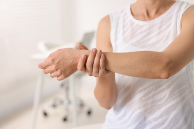 Sports injury. Woman with pain in wrist in hospital, closeup