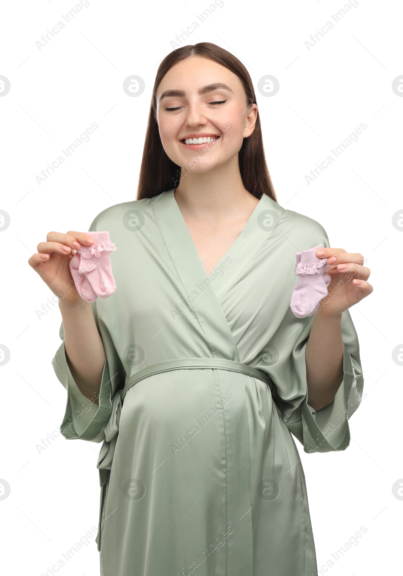 Photo of Expecting twins. Pregnant woman holding two pairs of socks on white background