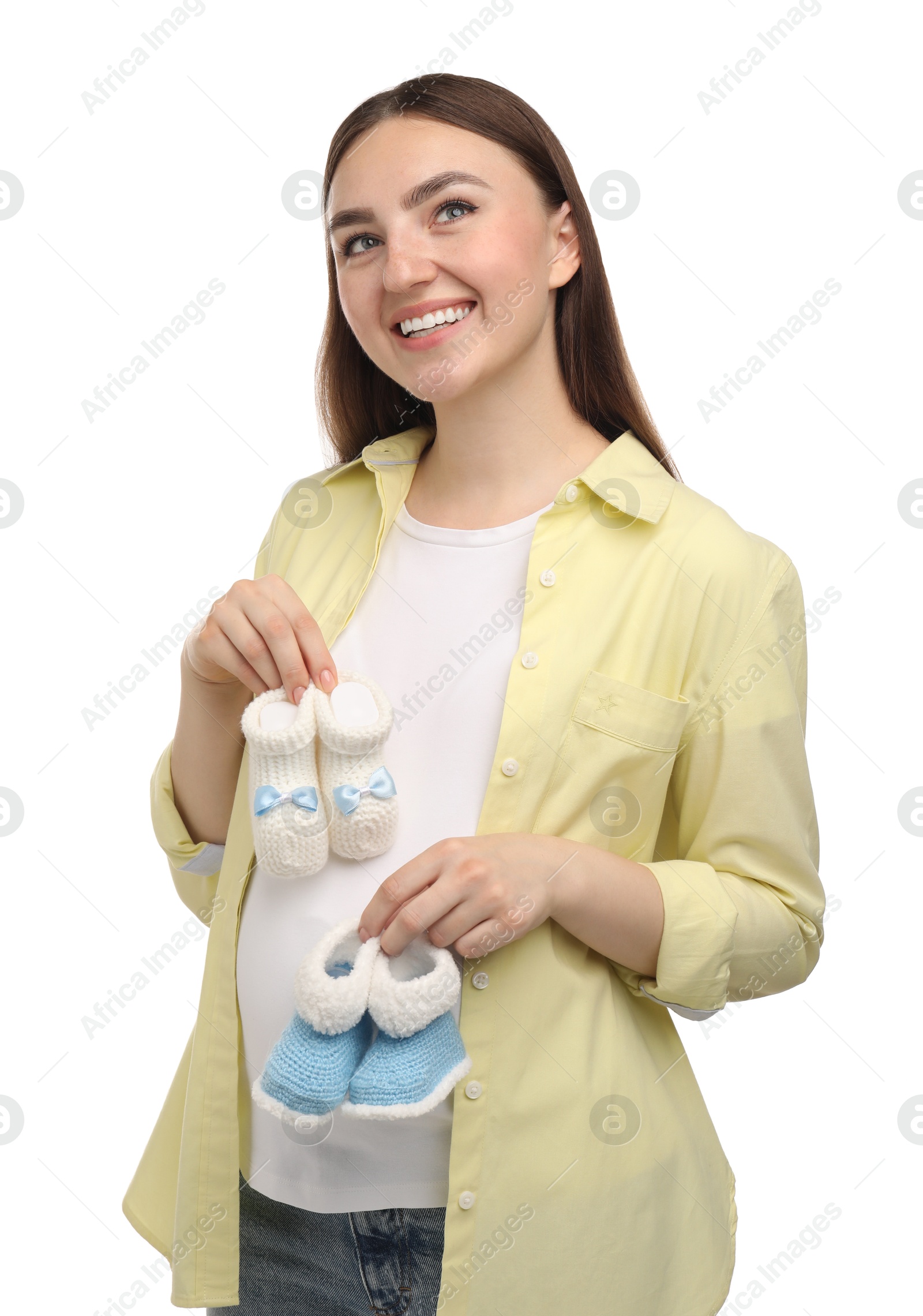 Photo of Expecting twins. Pregnant woman holding two pairs of baby shoes on white background