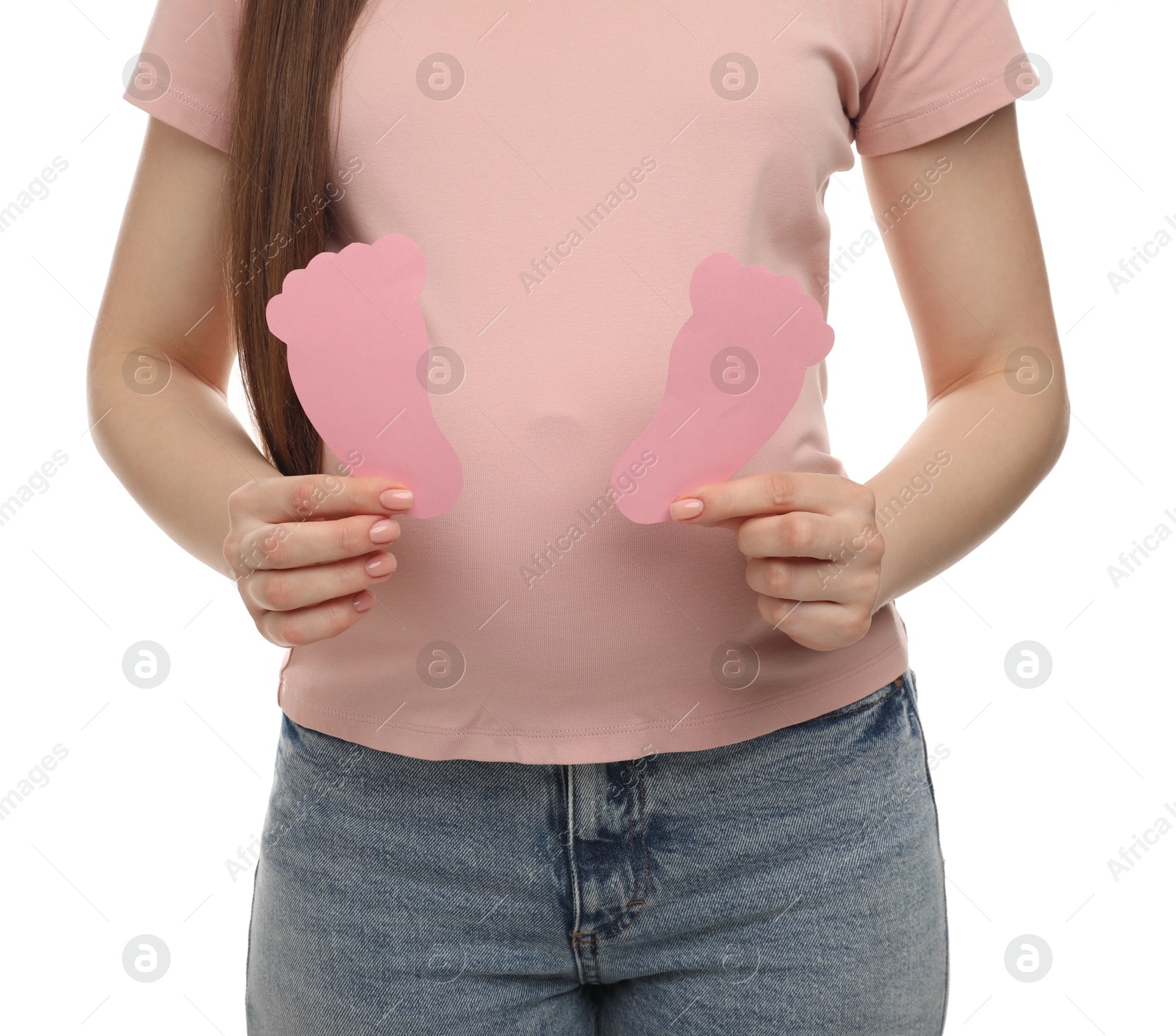 Photo of Expecting twins. Pregnant woman holding two paper cutouts of feet on white background, closeup