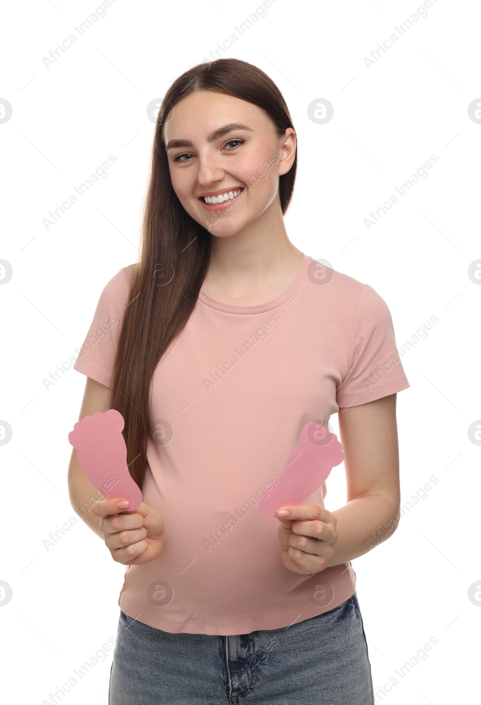 Photo of Expecting twins. Pregnant woman holding two paper cutouts of feet on white background