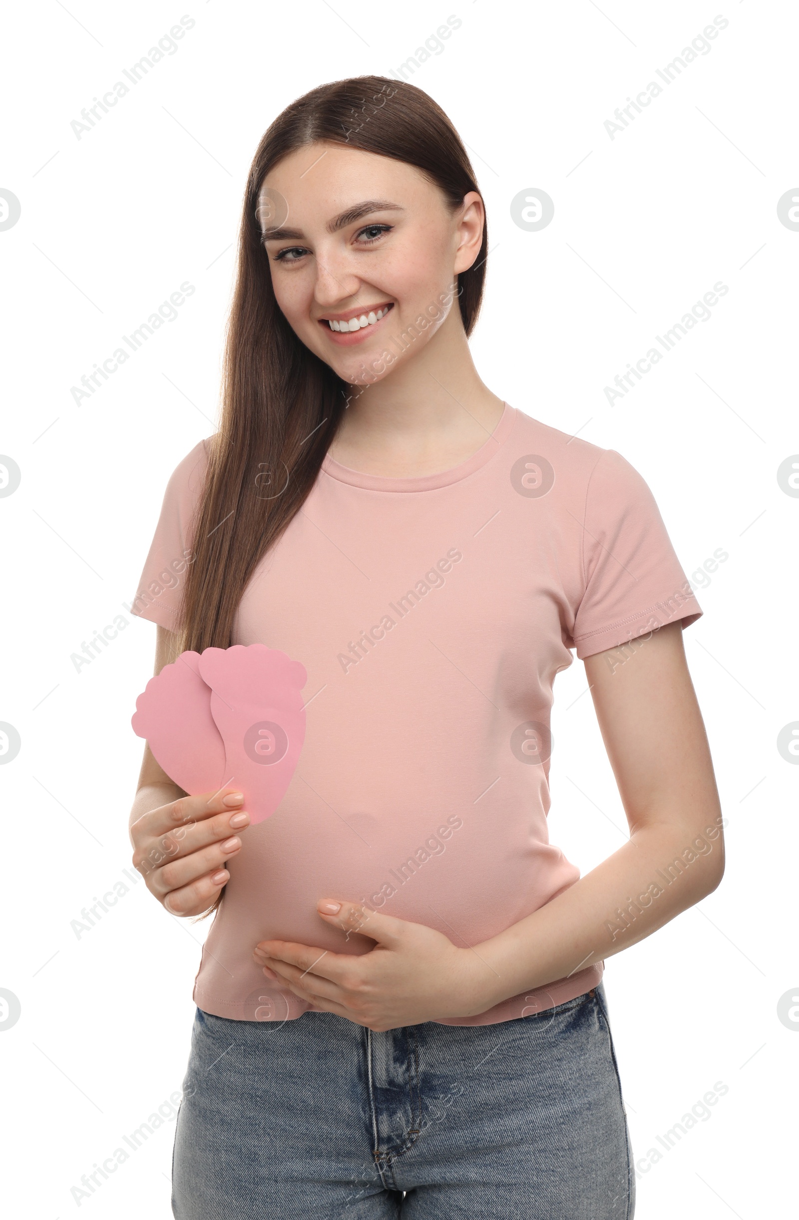 Photo of Expecting twins. Pregnant woman holding two paper cutouts of feet on white background