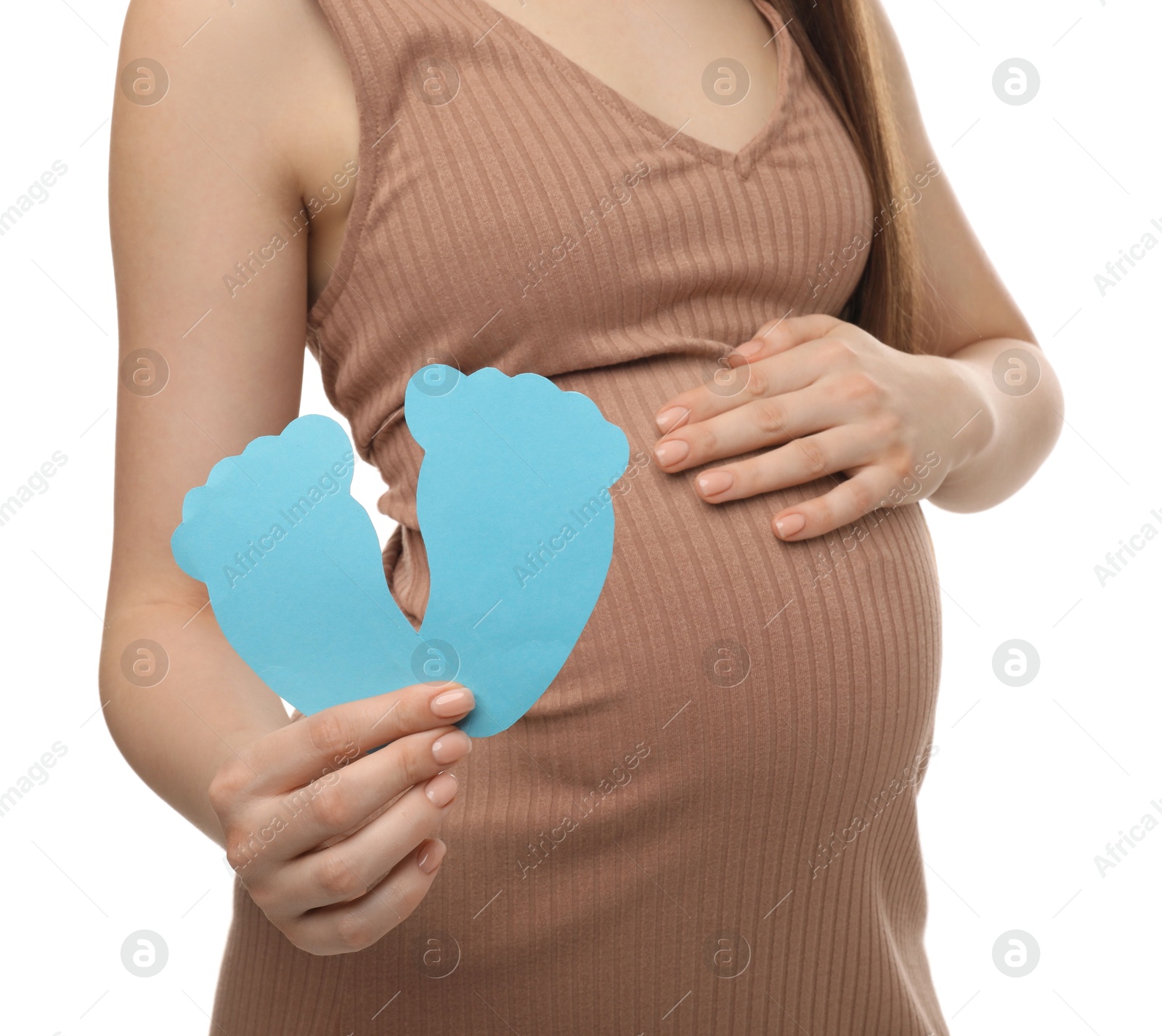 Photo of Expecting twins. Pregnant woman holding two paper cutouts of feet on white background, closeup