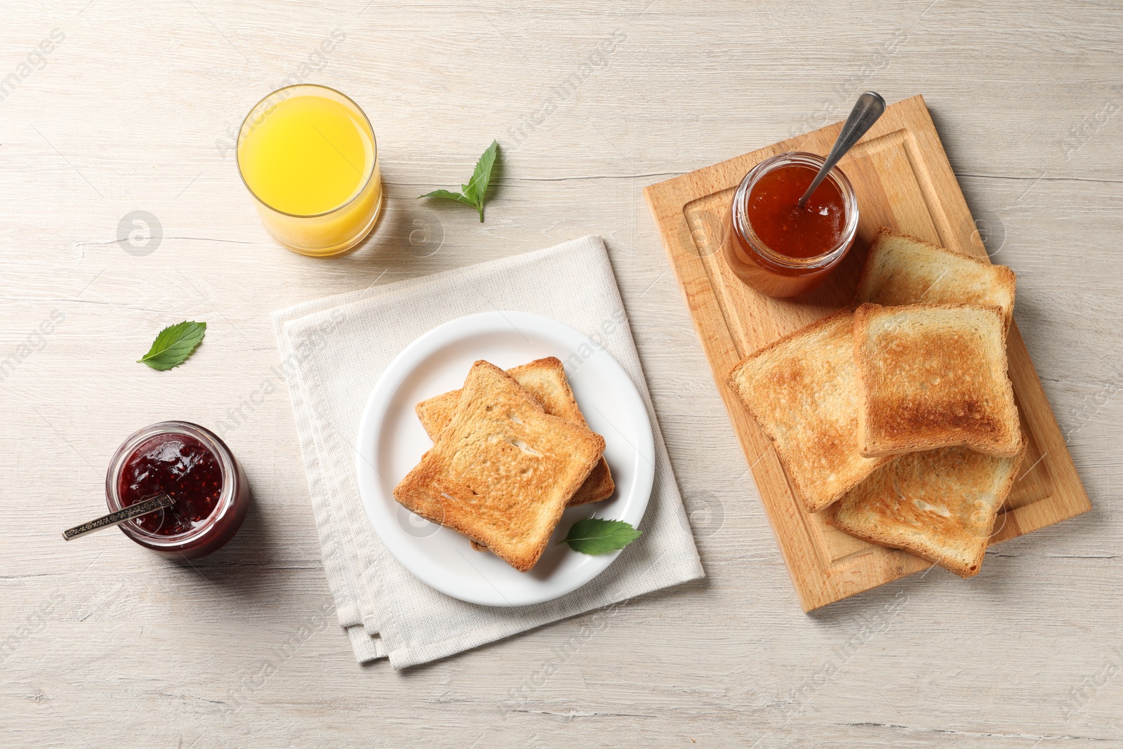 Photo of Delicious toasts served on wooden table, flat lay