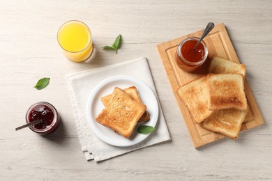 Delicious toasts served on wooden table, flat lay