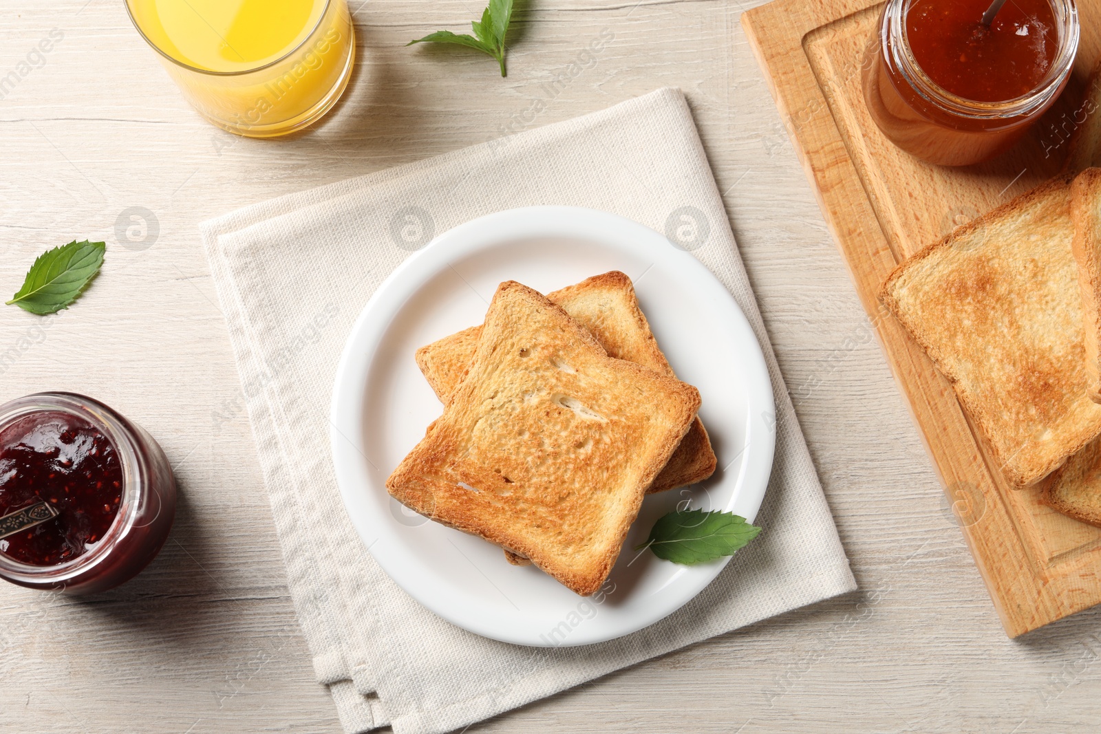 Photo of Delicious toasts served on wooden table, flat lay