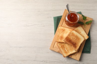 Delicious toasts and jam on wooden table, top view. Space for text