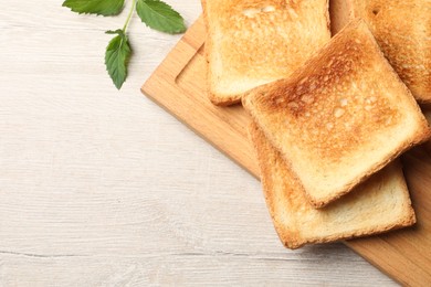 Photo of Slices of delicious toasted bread on wooden table, top view. Space for text