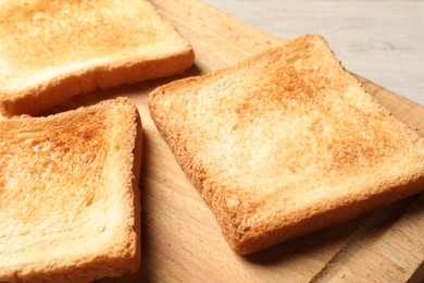 Photo of Slices of delicious toasted bread on wooden table, closeup