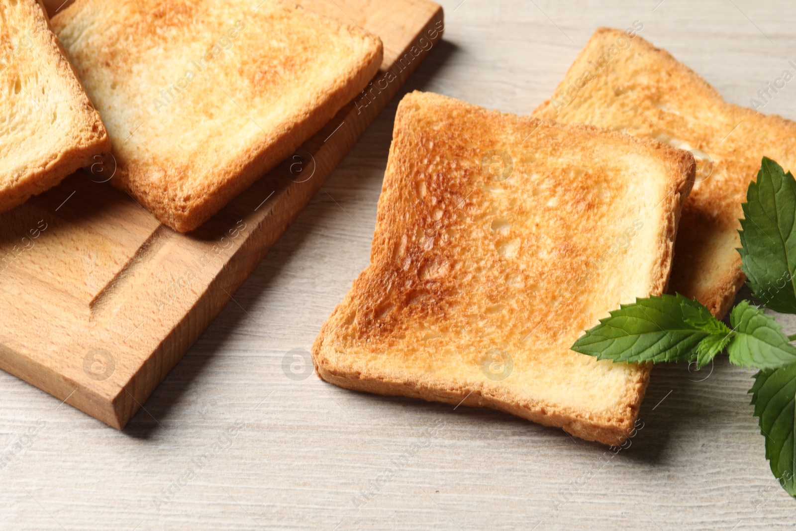 Photo of Slices of delicious toasted bread on wooden table, closeup