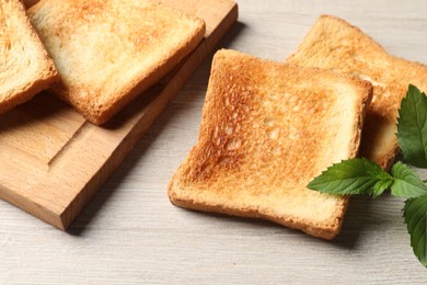 Photo of Slices of delicious toasted bread on wooden table, closeup