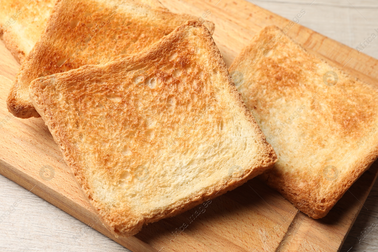 Photo of Slices of delicious toasted bread on wooden table, closeup