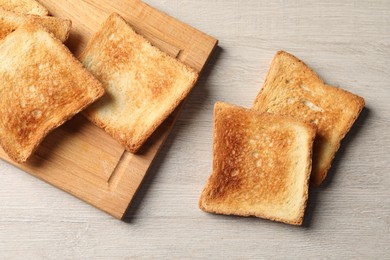 Slices of delicious toasted bread on wooden table, top view