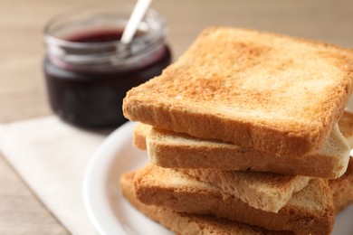 Delicious toasts and jam on wooden table, closeup