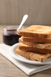 Delicious toasts and jam on wooden table, closeup