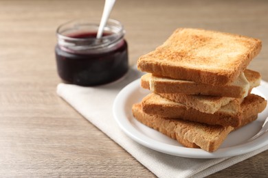 Photo of Delicious toasts and jam on wooden table