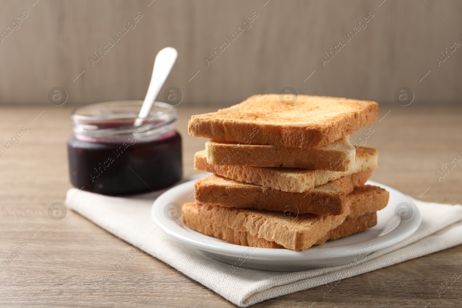 Photo of Delicious toasts and jam on wooden table