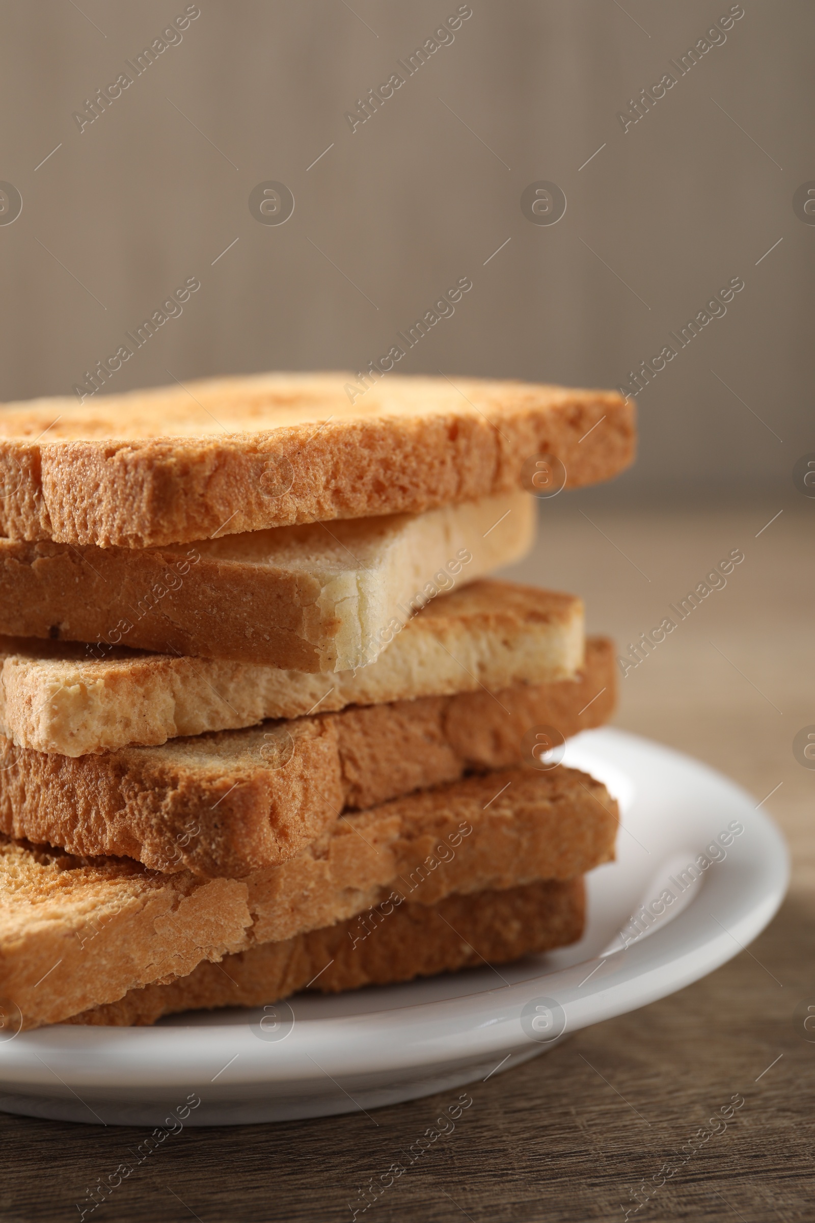 Photo of Stack of delicious toasted bread slices on wooden table