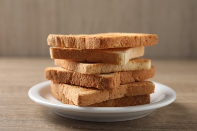 Stack of delicious toasted bread slices on wooden table