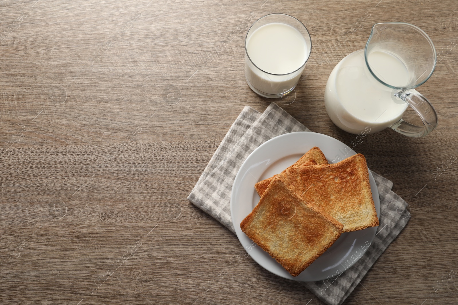 Photo of Delicious toasts with milk on wooden table, top view. Space for text