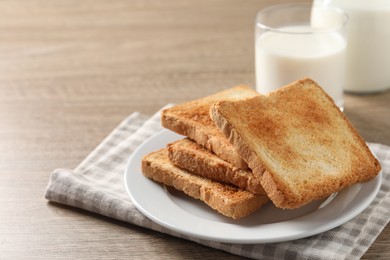 Photo of Delicious toasts with milk on wooden table